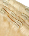 Set of blonde hair extensions with clips on a light background